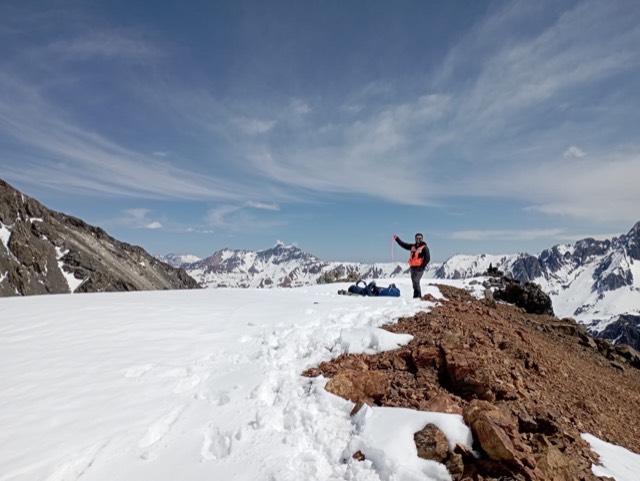 Profesional sobre un campo de nieve y cumbres andinas