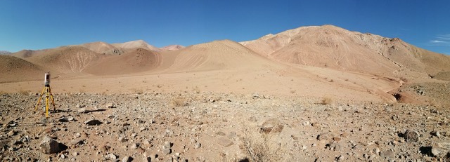 Paisaje árido con depósitos de material en una quebrada