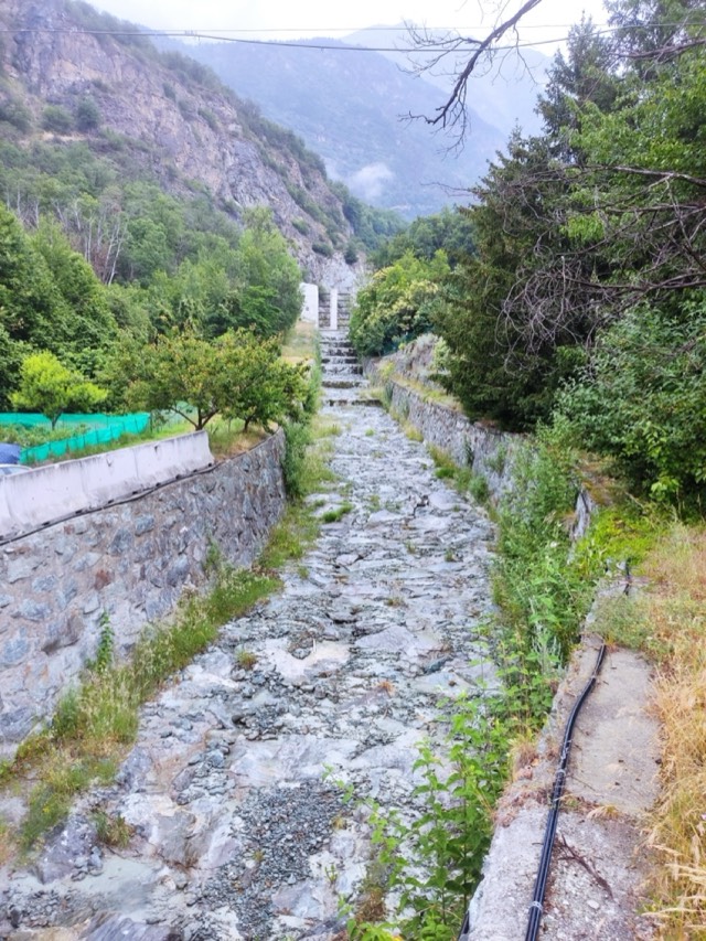 Canal revestido en piedra en una quebrada alpina