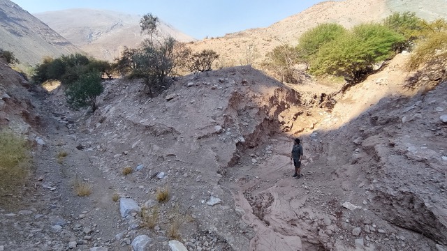 Cauce erosionado en una quebrada con un profesional como escala