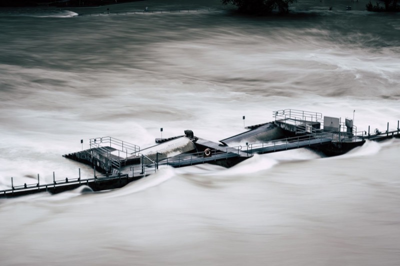 Estructura hidráulica rodeada por un río en crecida